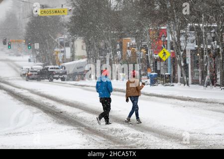 Seattle, Washington, USA. 26th Dez 2021. Fußgänger überqueren vorsichtig die West Seattle Junction, während am Sonntag, dem 26. Dezember 2021, ein Wintersturm Seattle trifft. Quelle: Paul Christian Gordon/Alamy Live News Stockfoto