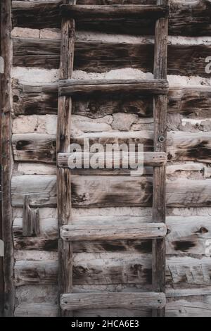 Der senkrechte Schuss der hölzernen Leiter gegen die Wand Stockfoto