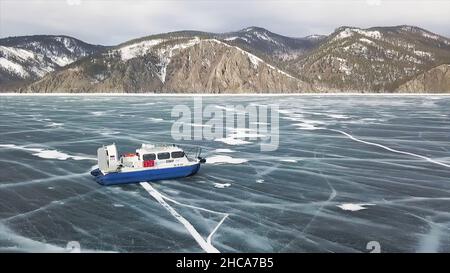 Hovercraft Transport auf dem gefrorenen See Baikal Sibirien, Russland. Luftaufnahme der malerischen Winterlandschaft mit hohen Bergen, gefrorenem See und Blau Stockfoto