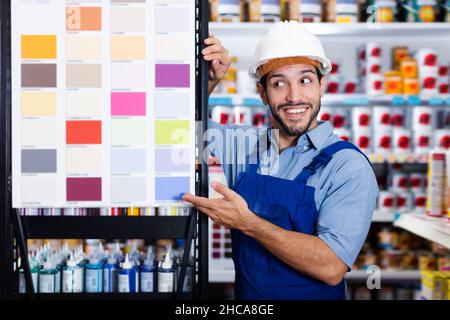 Junger Vorarbeiter, der Farbproben zeigt Stockfoto