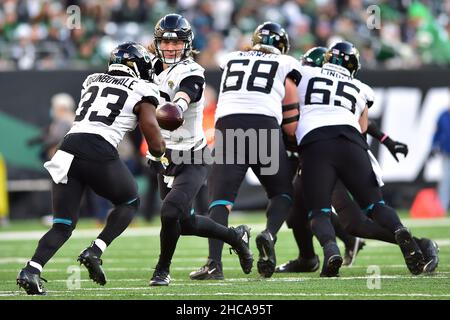 East Rutherford, New Jersey, USA. 26th Dez 2021. Jacksonville Jaguars Quarterback TREVOR LAWRENCE (16) übergibt sich an Jacksonville Jaguars, die zurück INS DARE OGUNBOWALE (33) im MetLife Stadium in East Rutherford New Jersey laufen New York besiegt Jacksonville 26 bis 21 (Bildnachweis: © Brooks von Arx/ZUMA Press Wire) Bildnachweis: ZUMA Press, Inc./Alamy Live News Stockfoto