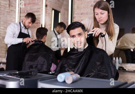 Friseur dabei Styling von Kerl mit elektrischen Haarschneider Stockfoto