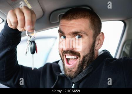 Mann zeigt Schlüssel von Neuwagen Stockfoto