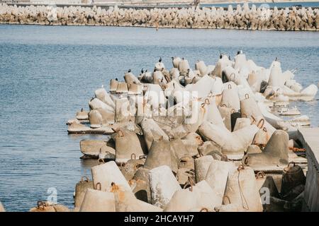 Küstenbrecher schützen vor großen Wellen mit Meeresgrund. Die Küste ist mit Betontetrapoden verstärkt. Stockfoto