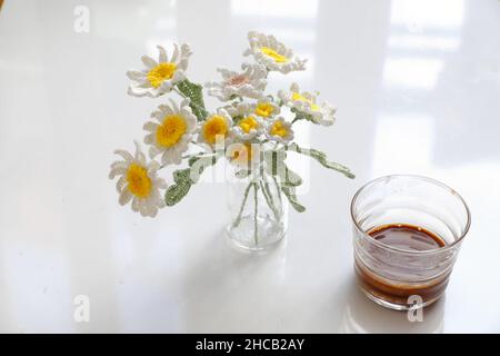 Erstaunlicher handgefertigter Blumentopf für Wohnkultur, weiße Blütenblätter Gänseblümchen und gelbes Pistill-Häkeln aus Garn bei Freizeitaktivitäten auf weißem Hintergrund Stockfoto