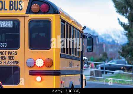 Gelber Schulbus fährt entlang der Straße in British Columbia, Kanada Stockfoto