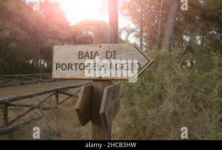 Porto Selvaggio, Apulien, Italien. August 2021. Ein hölzernes Hinweisschild weist auf die Richtung zur Bucht entlang des Pinienwaldes hin. Stockfoto