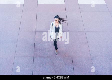 Frau in weißer Jacke, die mit Pferdeschwanz schwingt Stockfoto
