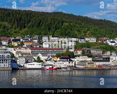 Traditionelle alte Lagerhäuser und Gebäude entlang der Uferpromenade von Old BergenÕs an einem hellen Tag in den bewaldeten Hügeln. Stockfoto