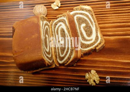 Nussbaum-Pastry 'Potica' auf verkohltem Holz Hintergrund. In Slowenien ist dieser Kuchen so traditionell, dass er Teil der nationalen Identität ist Stockfoto