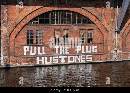 Ziehen Sie das Plug Hustones-Graffiti an der Ufermauer an der Spree in der Stadt Berlin. Stockfoto