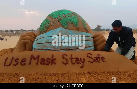 Der indische Sandkünstler Ajay Rawat kreiert am 26. Dezember 2021 in der Wüste von Pushkar, Rajasthan, Indien, Sandkunst für die Aufmerksamkeit auf das Coronavirus. Foto von Himanshu Sharma/ABACAPRESS.COM Stockfoto