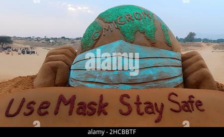 Der indische Sandkünstler Ajay Rawat kreiert am 26. Dezember 2021 in der Wüste von Pushkar, Rajasthan, Indien, Sandkunst für die Aufmerksamkeit auf das Coronavirus. Foto von Himanshu Sharma/ABACAPRESS.COM Stockfoto