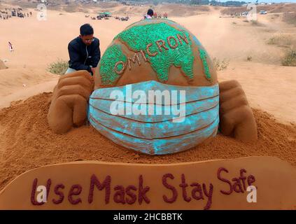 Der indische Sandkünstler Ajay Rawat kreiert am 26. Dezember 2021 in der Wüste von Pushkar, Rajasthan, Indien, Sandkunst für die Aufmerksamkeit auf das Coronavirus. Foto von Himanshu Sharma/ABACAPRESS.COM Stockfoto