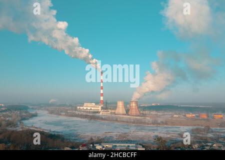 Verschmutzung des weißen Smokestack durch Kohle- und Braunkohleverbrennung in der Wärmekraftanlage in der Nähe der Stadt. Auswirkungen des Menschen auf den Klimawandel: Emissionen von thermischen Kraftwerken, die die Luft verschmutzen. Stockfoto