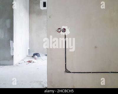 Verdrahtung. Steckdosen und Kabel in der Wand - Zimmerreparatur Stockfoto