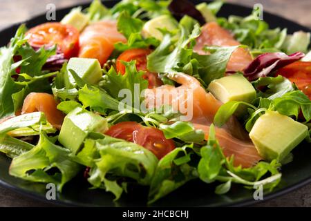 Lachs- und Avocado-Salat auf Holztisch Stockfoto