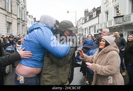 Lewes UK 27th December 2021 - Ein Profi-Hunt-Unterstützer (links) versucht, sich bei der Southdown and Eridge Hunt Parade durch das Stadtzentrum von Lewes am Weihnachtsfeiertag in Großbritannien ein Banner für die Jagd zu sichern : Credit Simon Dack / Alamy Live News Stockfoto