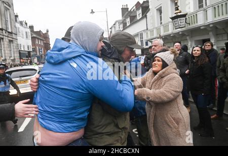 Lewes UK 27th December 2021 - Ein Profi-Hunt-Unterstützer (links) versucht, sich bei der Southdown and Eridge Hunt Parade durch das Stadtzentrum von Lewes am Weihnachtsfeiertag in Großbritannien ein Banner für die Jagd zu sichern : Credit Simon Dack / Alamy Live News Stockfoto