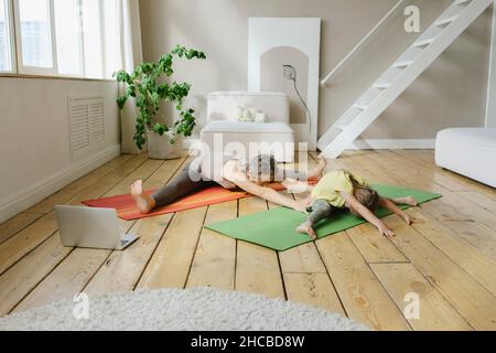 Mutter und Tochter praktizieren zu Hause Yoga Stockfoto