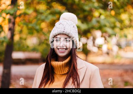 Junge Frau mit Strickmütze im Herbstpark Stockfoto