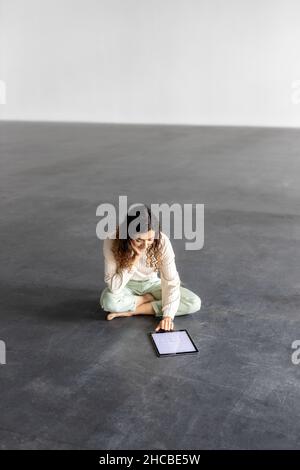 Junge Geschäftsfrau, die in der Industriehalle am Tablet-pc arbeitet Stockfoto