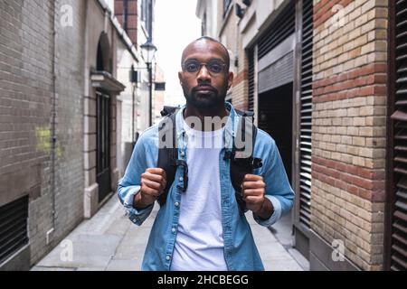Mann mit Rucksack, der in der Gasse steht Stockfoto
