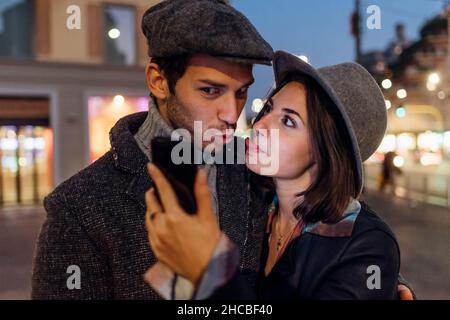 Freundin und Freund machen lustige Gesichter, während sie Selfie über das Smartphone machen Stockfoto