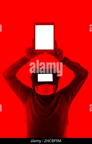 Mann mit futuristischem Helm und digitalem Tablet mit leerem Bildschirm Stockfoto