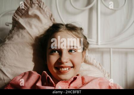 Betrachten Mädchen lächeln auf dem Bett zu Hause Stockfoto