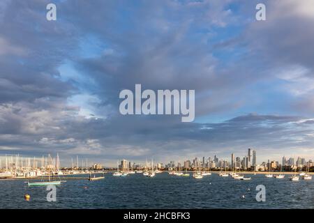 Australien, Victoria, Melbourne, Yachten, die in der Abenddämmerung gegen die beleuchtete Skyline der Stadt schweben Stockfoto