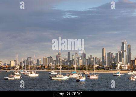 Australien, Victoria, Melbourne, Yachten, die in der Abenddämmerung gegen die beleuchtete Skyline der Stadt schweben Stockfoto