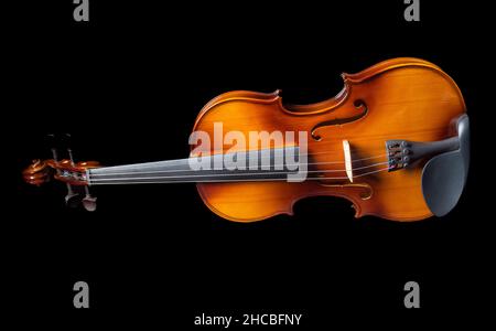 Violine liegt auf seiner Seite isoliert auf schwarzem Hintergrund. Speicherplatz kopieren. Stockfoto