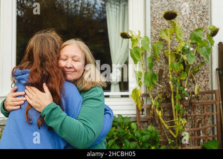 Mädchen in Brillen Blick auf Herzformen auf transparentem Fenster zu Hause Stockfoto