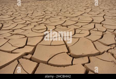 Nahaufnahme der trockenen gerissenen Erde. Trockenes Flussbett. Verhüllter Wüstenboden. Konzept der globalen Erwärmung. Stockfoto