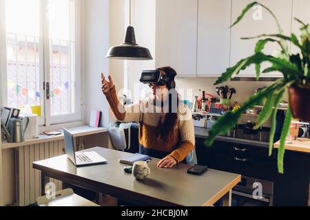 Frau, die zu Hause ein Virtual-Reality-Headset trägt Stockfoto