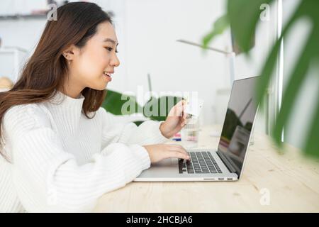 Junge Geschäftsfrau winkt bei einem Videoanruf über einen Tablet-PC zu Hause mit der Hand Stockfoto