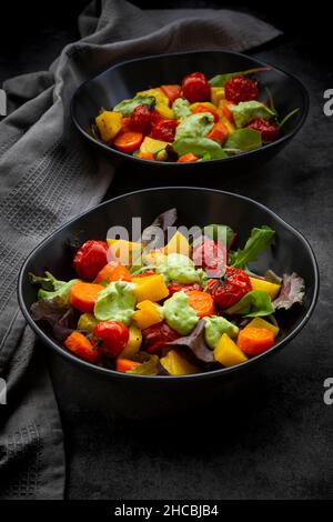 Studioaufnahme von zwei Schüsseln veganen Salats mit gebackenem Gemüse Stockfoto