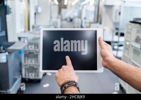 Geschäftsmann mit digitalem Tablet in der Fabrik Stockfoto