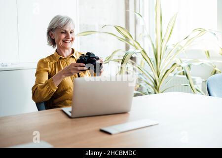 Geschäftsfrau, die im Büro mit dem Mobiltelefon spricht Stockfoto