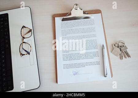 Brillen auf Laptop per Vertragsdokument mit Stift und Schlüsselbund Stockfoto