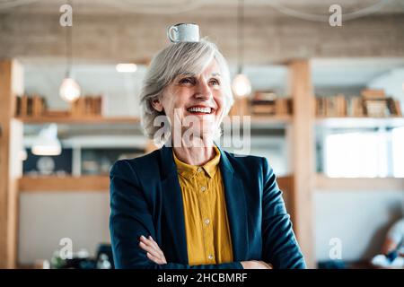 Eine Geschäftsfrau, die am Arbeitsplatz mit einem Smartphone spricht Stockfoto