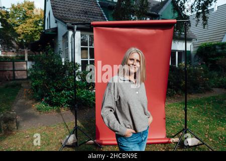 Lächelnder Mann Huckepack verspielte Frau im Hinterhof Stockfoto