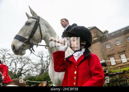 Hagley, Worcestershire, Großbritannien. 27th Dez 2021. Der 8-jährige Henley Mills bläst bei der ersten Albrighton- und Woodland-Jagd in der Hagley Hall seit der Coronavirus-Pandemie sein Horn. Die Albrighton und Woodland Hunt treffen sich jährlich in der Hagley Hall in Worcestershire. Kredit: Peter Lopeman/Alamy Live Nachrichten Stockfoto