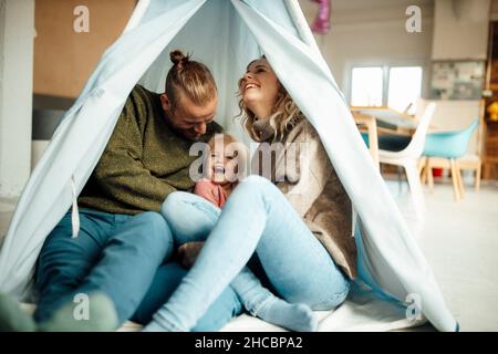 Familie sitzt zusammen im Zelt zu Hause Stockfoto