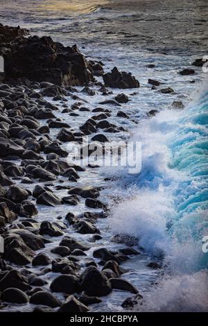 Wellen, die gegen die felsige Küste von Praia de Santa Barbara plätschern Stockfoto