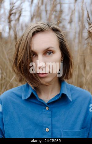 Junge Frau, die auf dem Boardwalk inmitten von Gras läuft Stockfoto