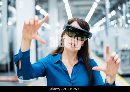 Geschäftsfrau, die Augmented-Reality-Brillen in der Industrie verwendet Stockfoto