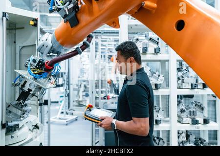 Wartungstechniker, der Roboterarm in der Industrie betreibt Stockfoto