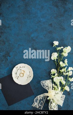 Studioaufnahme eines Paares goldener Eheringe, die vor braunem Hintergrund liegen Stockfoto